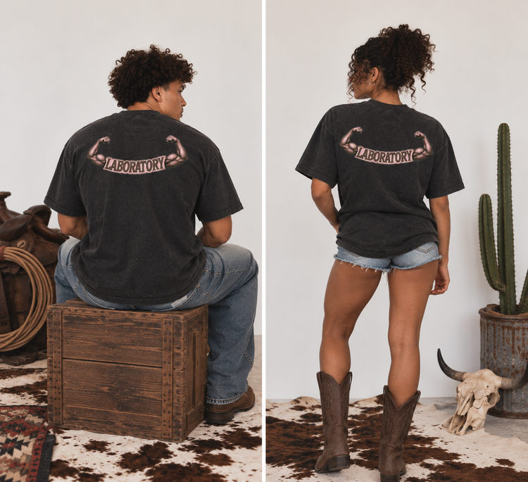 A split view showing a woman from the back wearing a faded black graphic t-shirt with a flexing muscular design and the word 'LABORATORY' on the back. She is seated on a wooden crate on the left and standing on a cowhide rug on the right, wearing denim shorts and boots in a rustic studio setting.