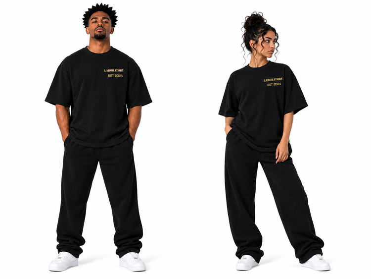 Two models wearing a black oversized t-shirt and sweatpants set with gold 'LONDONER EST. 2024' text on the chest, posed against a solid white background.
