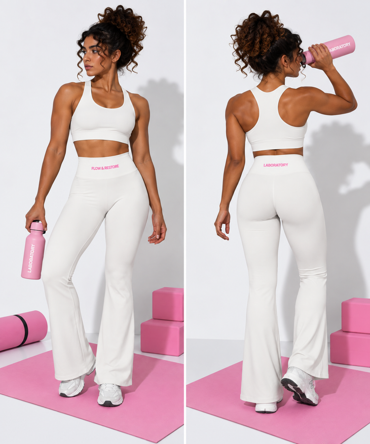 A woman modeling a matching white activewear set in a studio setting, shown from both front and back. The set includes a sports bra and high-waisted flared leggings with pink branding text on the waistbands.
