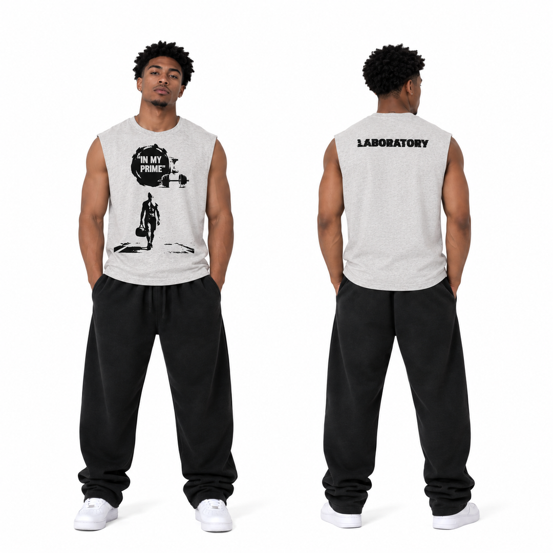 A male model shown from the front and back wearing a light gray sleeveless muscle tank top with black graphics and text, paired with black sweatpants and white sneakers, on a white studio background.