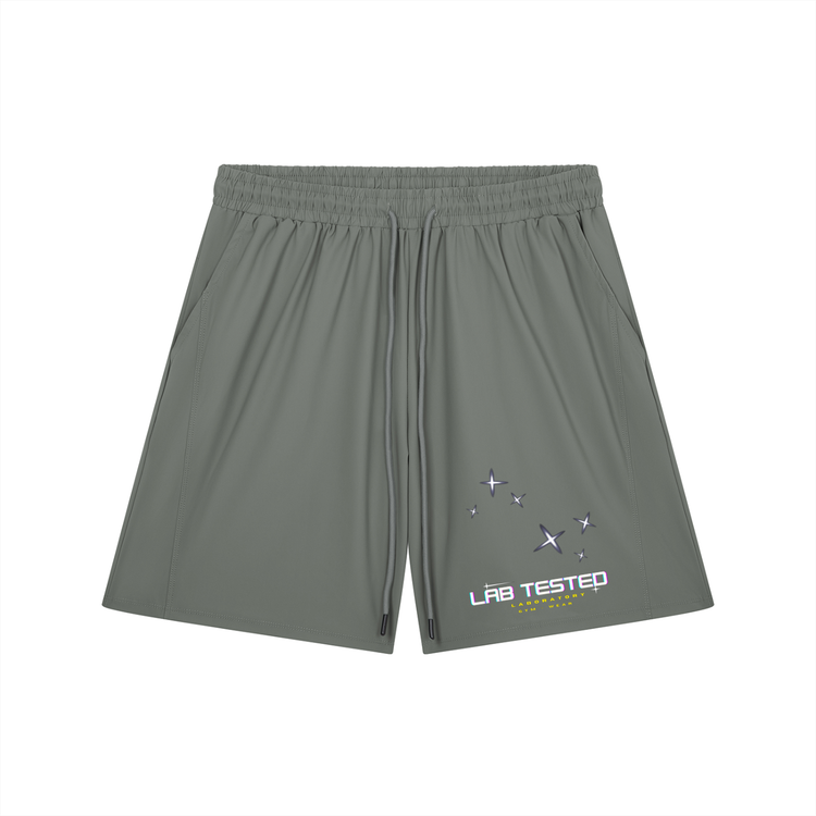 A pair of gray athletic shorts with an elastic waistband and drawstring, featuring a small graphic on the lower left leg with the text 'LAB TESTED' and star illustrations, displayed on a solid white background.