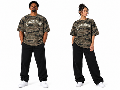 Two models wearing matching camouflage graphic t-shirts with 'Laboratory' printed in white gothic lettering across the chest, paired with black sweatpants and white sneakers, set against a plain white background.