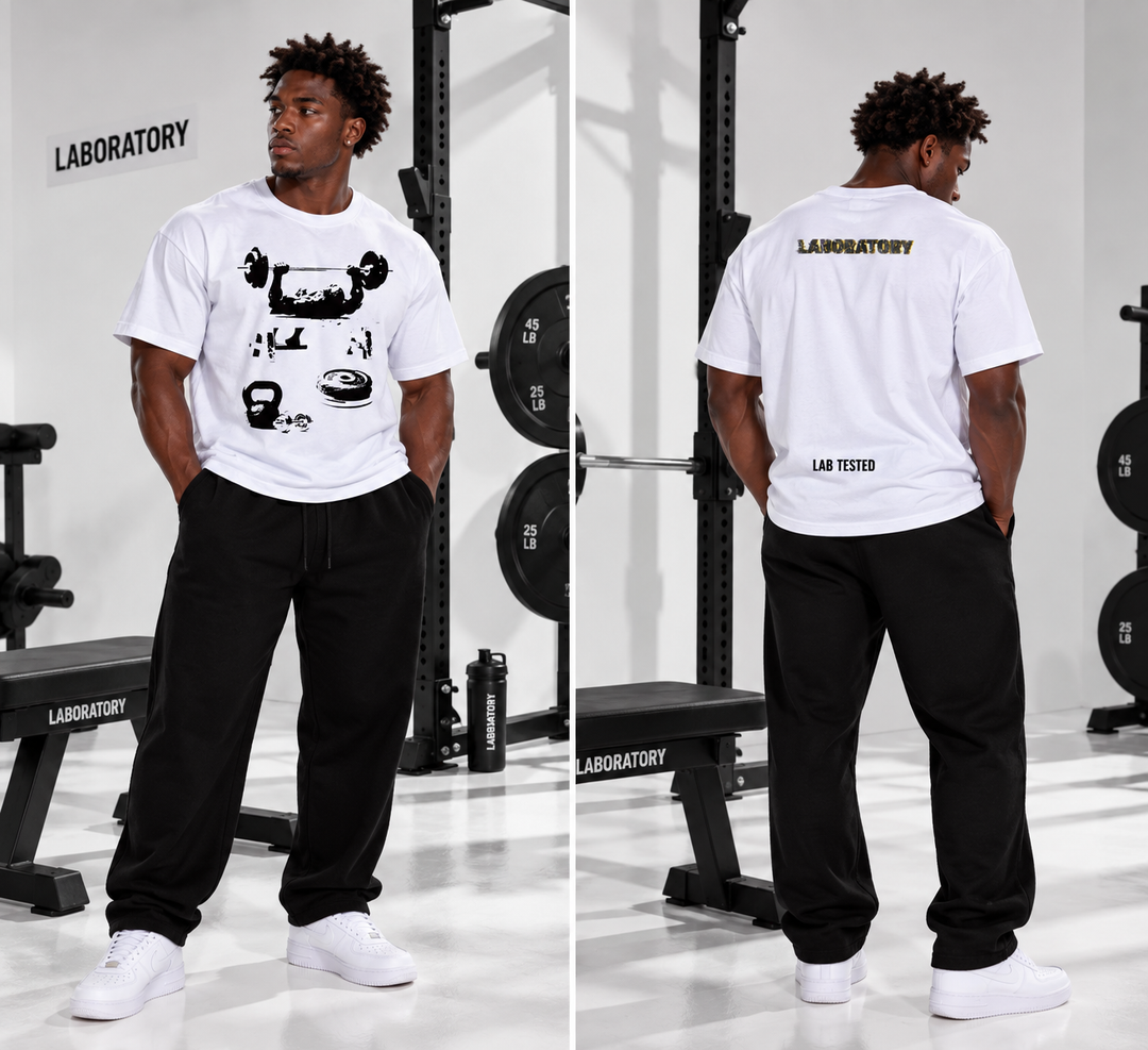 A man stands in a gym wearing a white short-sleeve t-shirt with a black graphic print on the front and a black back graphic, paired with black sweatpants and white sneakers. The image shows both front and back views side-by-side.