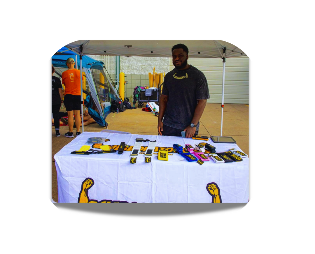 Person standing behind a table with various items on it, in an indoor setting.